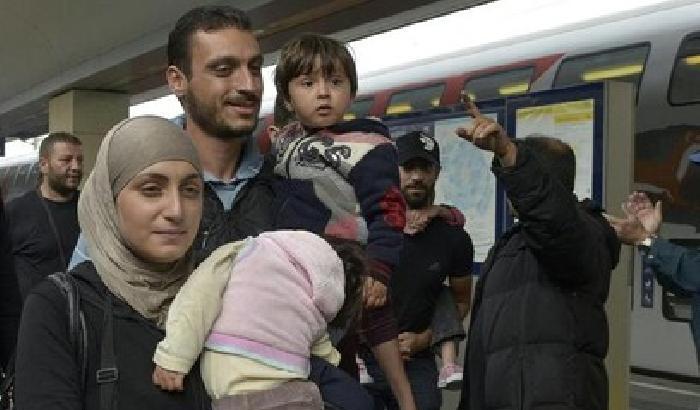 Profughi felici all'arrivo in Austria, accolti con cibo e bevande