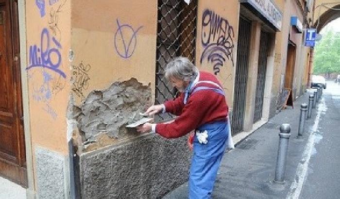 Gli abitanti di via Petroni a Bologna puliscono i muri 