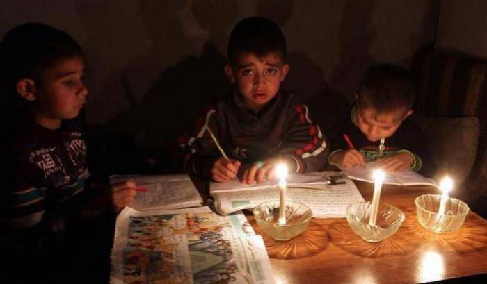 Bambini a Gaza studiano a lume di caldela a causa della crisi di energia elettrica