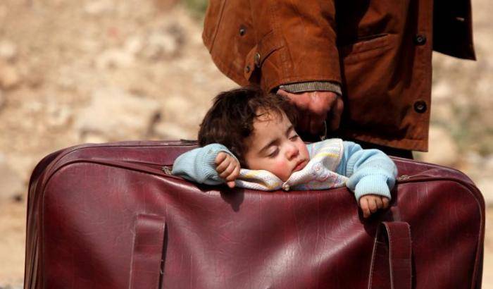 Un bambino in una valigia di alcuni profughi di Ghouta