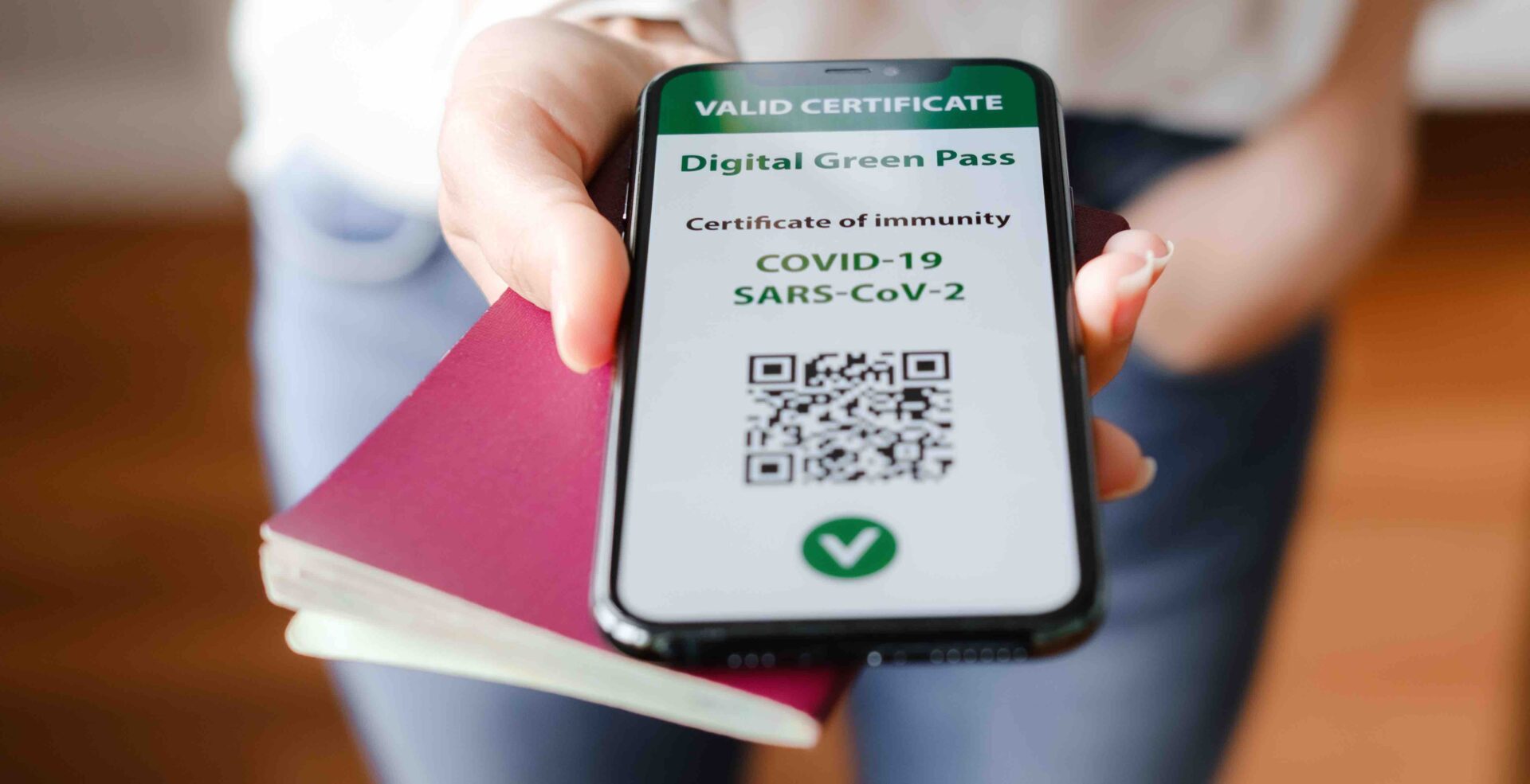Unrecognized woman holding smartphone with digital green pass and QR code on the screen. Health passport or certificate of immunity. Traveling without restrictions. Vaccinated person Cerca di imbarcarsi con un Green Pass di qualcun altro: denunciato