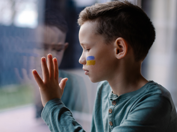 The,Child,Sits,At,The,Window,With,The,Flag,Of Il sindaco denuncia: i russi tengono in ostaggio i bimbi di Energodar